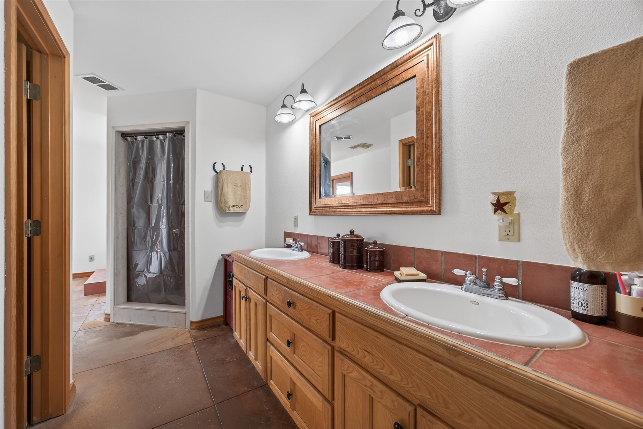 1077 Burdette Wells Road Lockhart, TX 78644 - Photo 22 of 38 a bathroom with a granite countertop double vanity sink mirror and