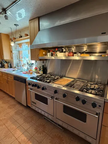 a stove top oven sitting inside of a kitchen
