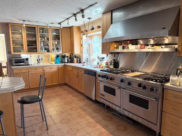 a kitchen with stainless steel appliances a stove a sink and a refrigerator
