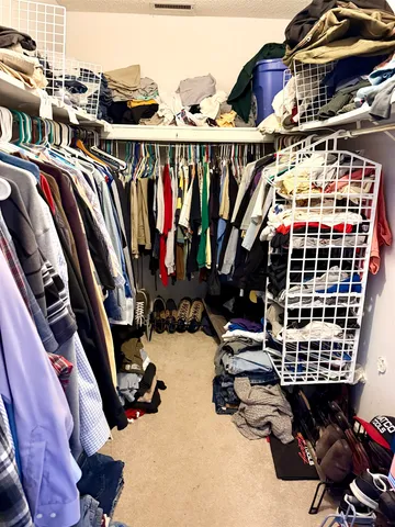 a view of walk in closet with clothes and shoes