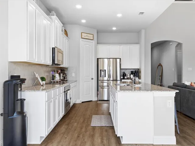 a kitchen with sink a refrigerator and cabinets