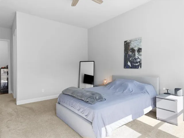 a bedroom with a bed and a painting on the wall