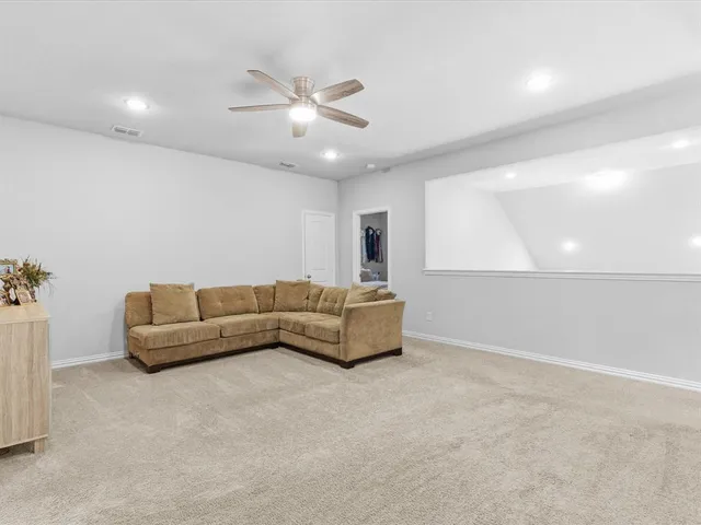 a living room with furniture and a ceiling fan