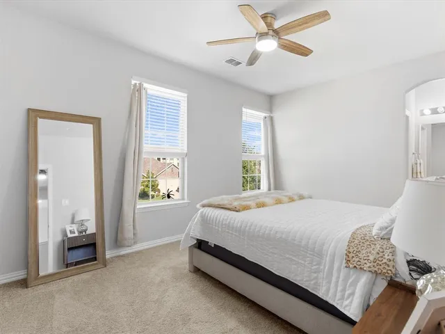 a bedroom with a bed and a large window