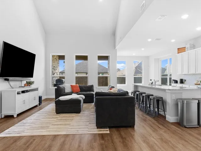 a living room with furniture a flat screen tv and kitchen view