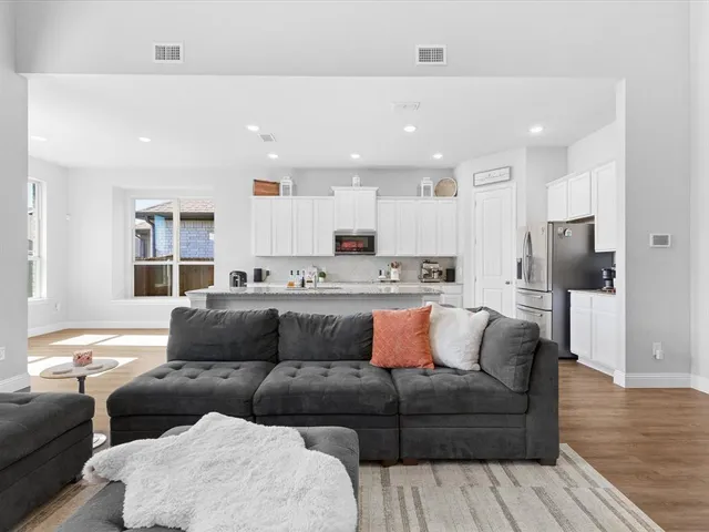 a living room with furniture and a wooden floor