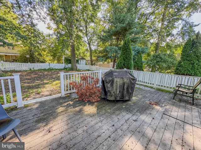 a view of a backyard with wooden floor and fence