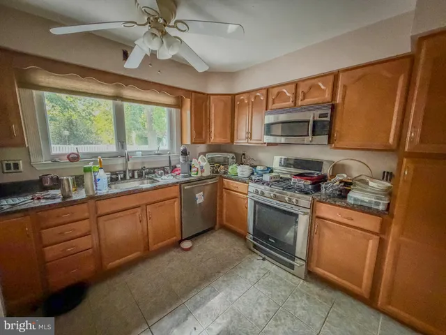 a kitchen with stainless steel appliances granite countertop a stove sink microwave and window