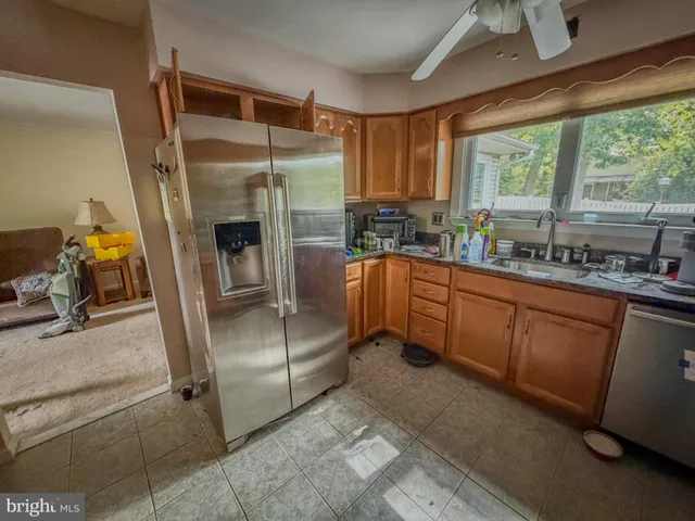 a kitchen with a sink refrigerator and window