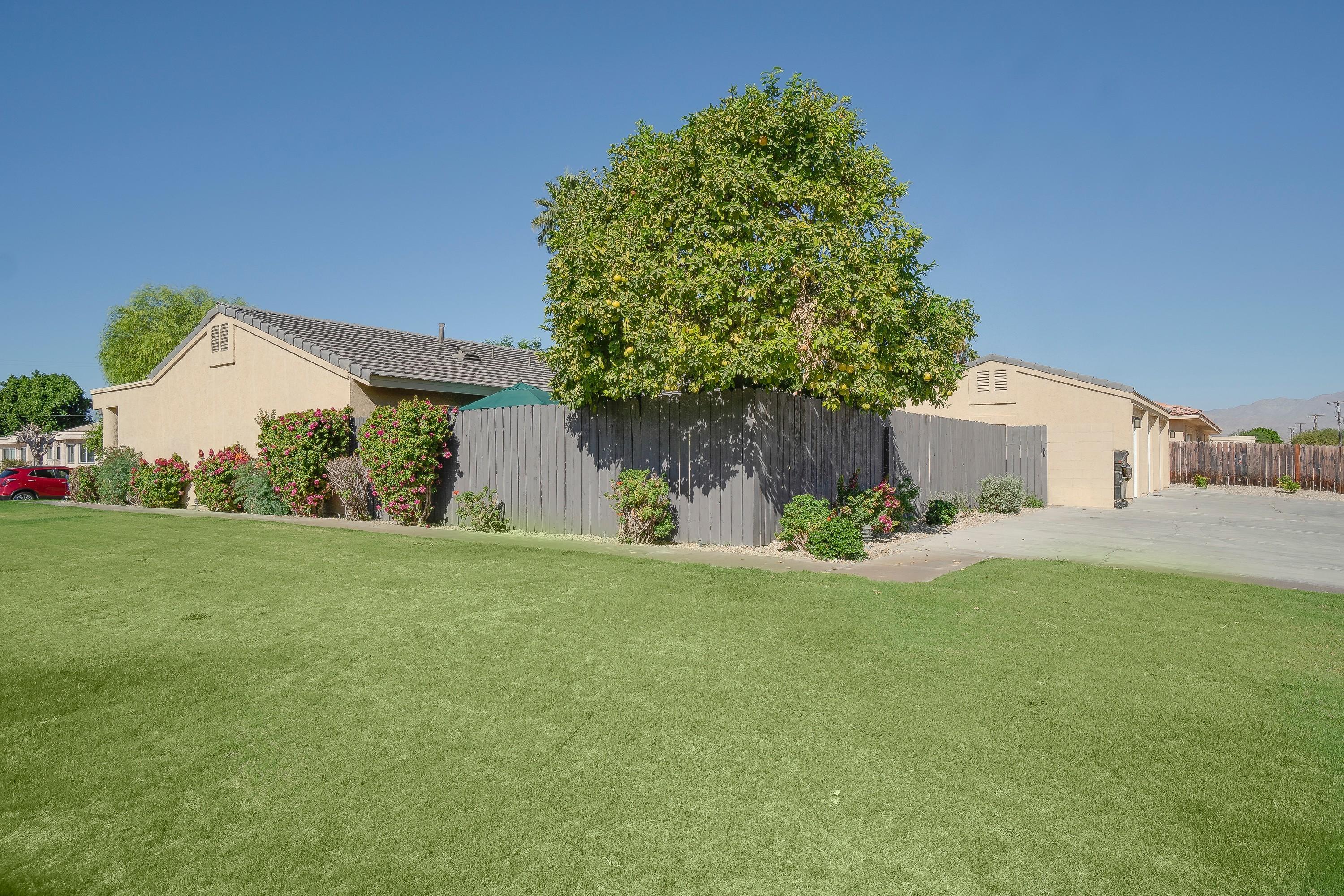 41680 Maroon Town Road, Unit B Bermuda Dunes, CA 92203 - Photo 2 of 19 a front view of a house with a yard and garage