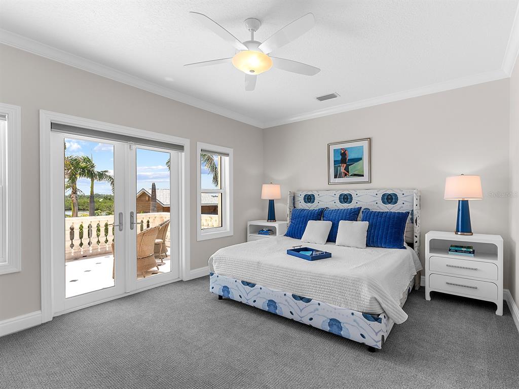 144 North Casey Key Road Nokomis, FL 34275 - Photo 36 of 54 a bedroom with a bed and a lamp on the dresser