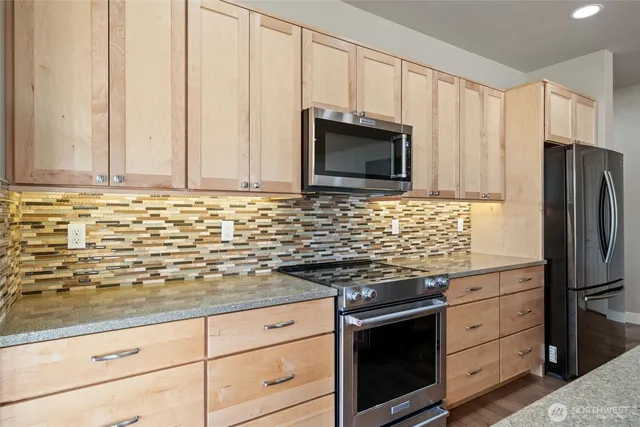a kitchen with granite countertop white cabinets and stainless steel appliances