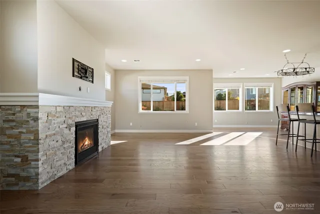 a view of an empty room with wooden floor and a fireplace