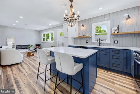 a kitchen with stainless steel appliances granite countertop a sink dishwasher stove and microwave with wooden floor