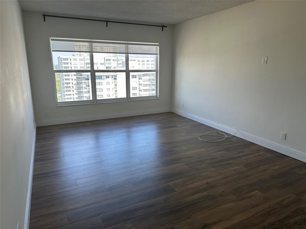 3550 Galt Ocean Drive, Unit 1907 Fort Lauderdale, FL 33308 - Photo 11 of 28 an empty room with wooden floor and windows