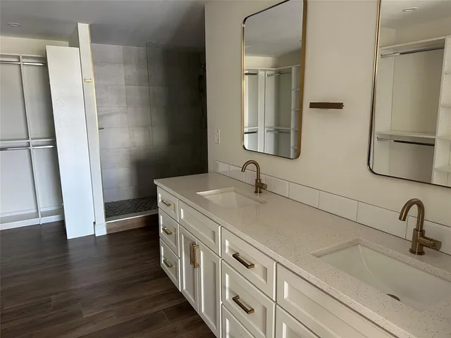 a bathroom with double vanity sink and mirror