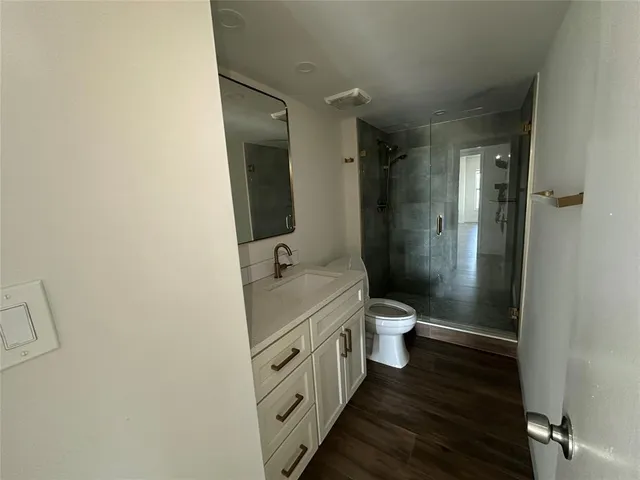 a bathroom with a granite countertop toilet a sink and a mirror