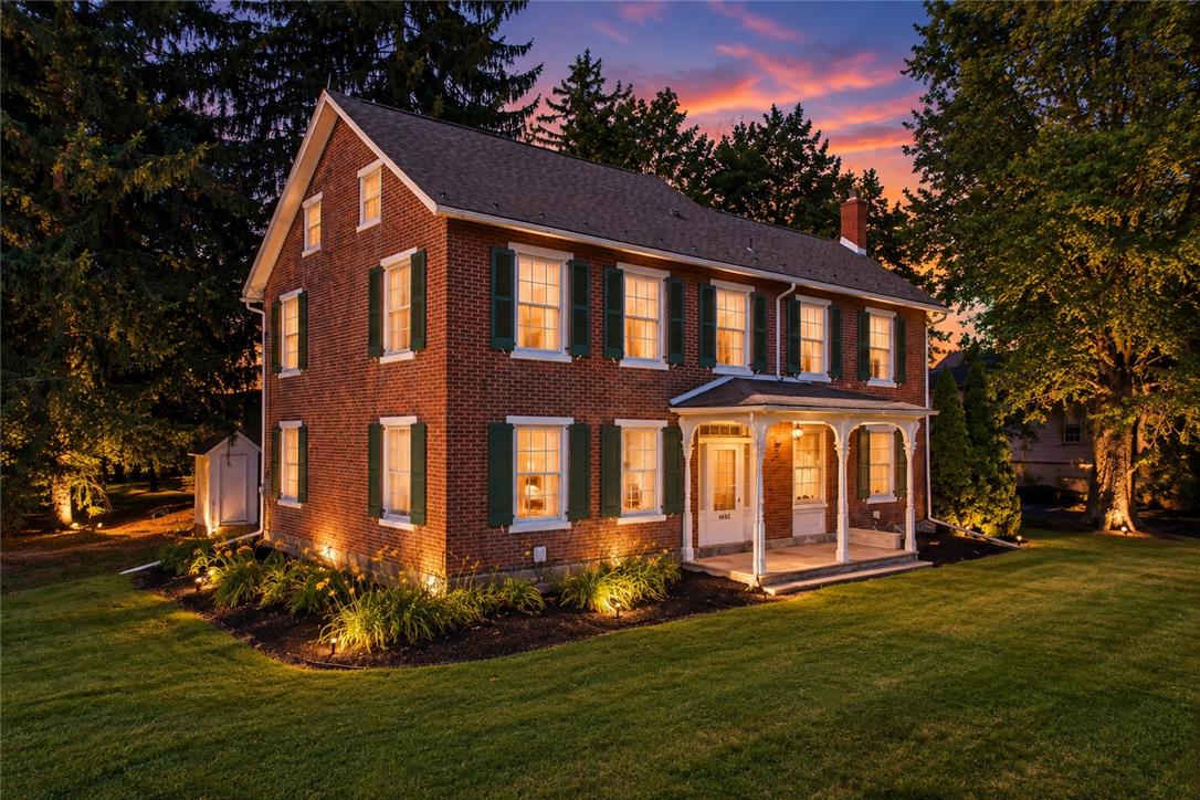 4682 Steuben Road Bethlehem, PA 18020 - Photo 2 of 85 A historic brick facade and welcoming front porch glow under a vibrant evening sky.