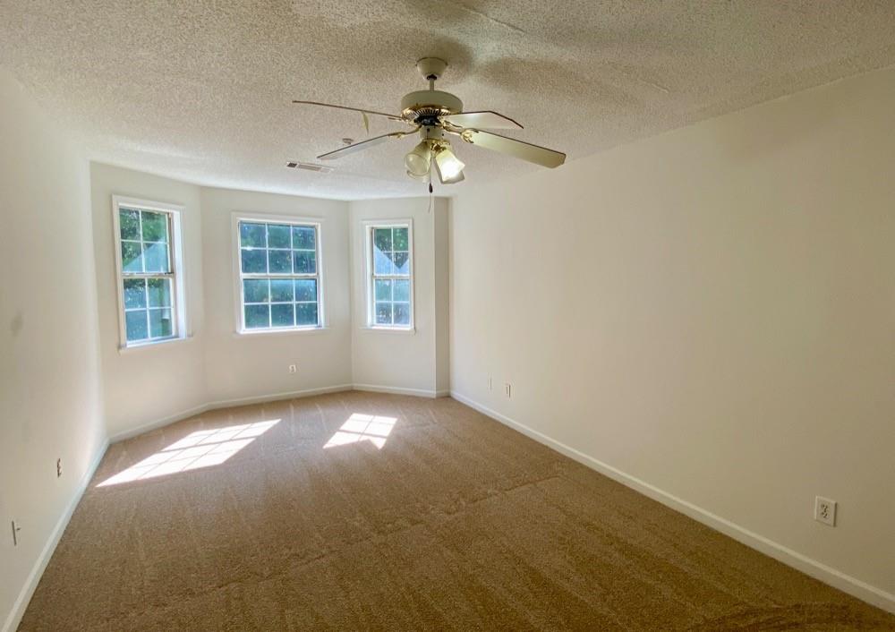 3808 Soapstone Road Decatur, GA 30034 - Photo 4 of 11 an empty room with windows and ceiling fan