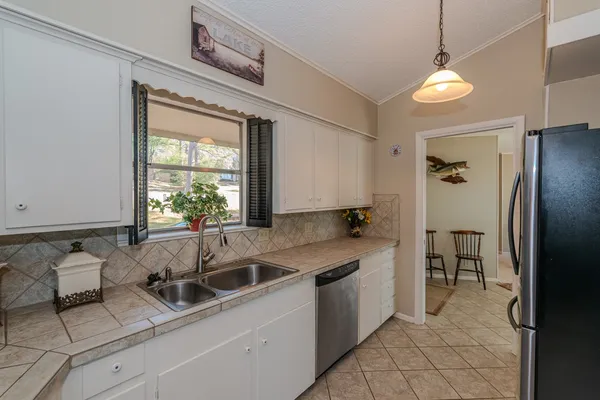 a kitchen that has a sink cabinets and a window