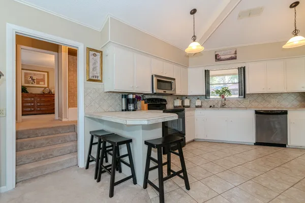 a kitchen with a table chairs sink and cabinets