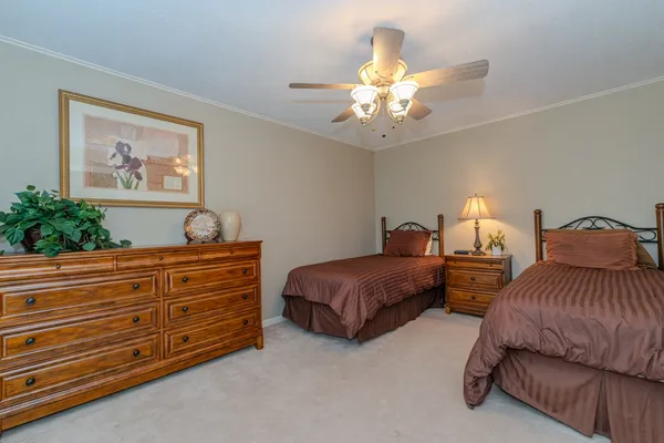 a spacious bedroom with a bed and a chandelier