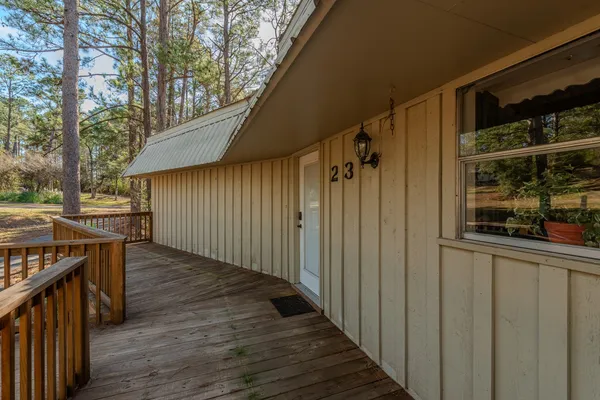 a view of a backyard with wooden floor and fence