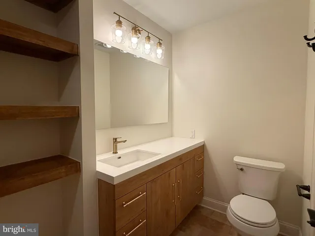 a bathroom with a toilet a sink and mirror