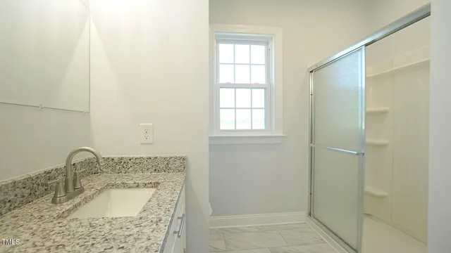 a bathroom with a sink a shower and a mirror