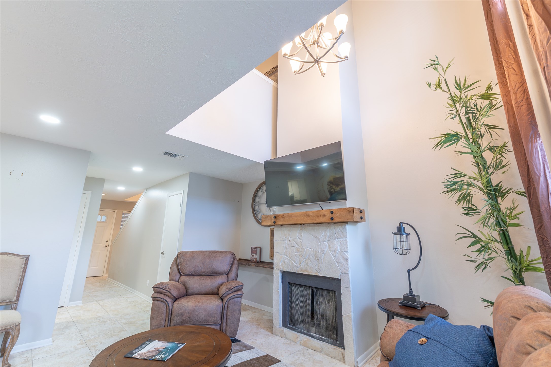 38 Regency Point Montgomery, TX 77356 - Photo 9 of 49 looking towards the back of the townhome. closet and stairs middle left, cubby space, fireplace, TV and chandelier on right