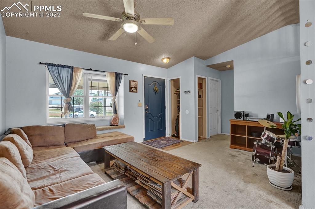 629 Blossom Field Road Fountain, CO 80817 - Photo 3 of 25 a living room with furniture a chandelier and a window