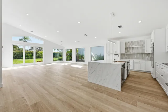 a kitchen with granite countertop white cabinets and stainless steel appliances