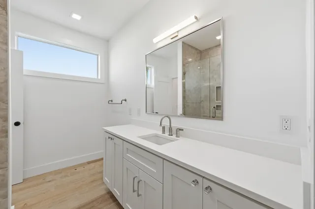 a large white kitchen with kitchen island a large counter top space