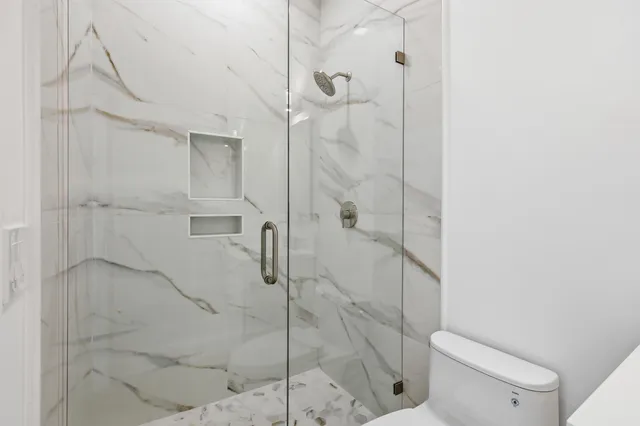 a view of an empty room with wooden floor and window