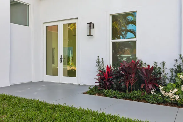 a view of an empty room with wooden floor and windows