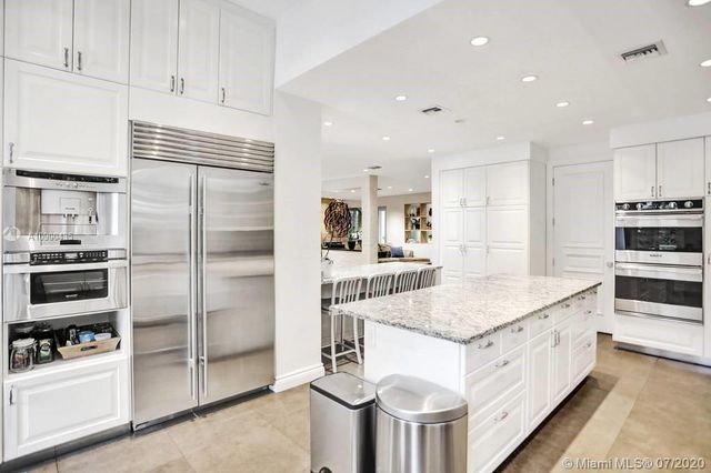 a kitchen with kitchen island a counter appliances and cabinets