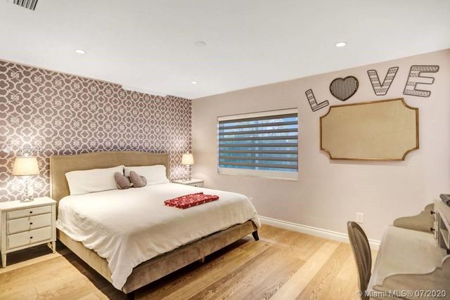 a bedroom with a bed and a lamp with the dresser