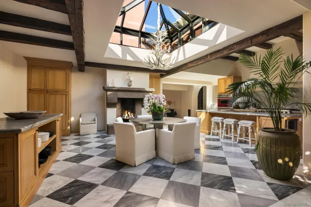 a dining room with wooden floor a chandelier a wooden table and chairs