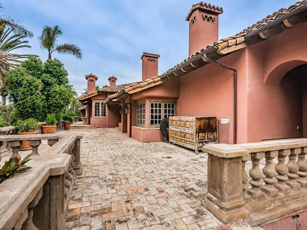 17116 Paseo Hermosa Rancho Santa Fe, CA 92067 - Photo 45 of 59 a front view of a house with large trees and outdoor seating