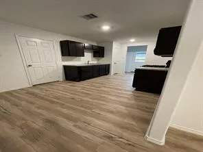 a kitchen with stainless steel appliances a refrigerator and a flat screen tv