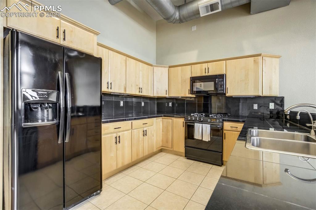 115 North Tejon Street, Unit B Colorado Springs, CO 80903 - Photo 15 of 43 a kitchen with stainless steel appliances granite countertop a refrigerator a stove a sink and a microwave