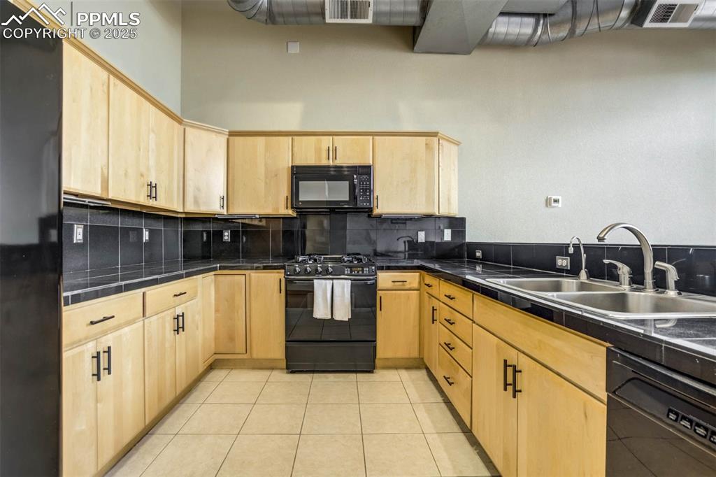 115 North Tejon Street, Unit B Colorado Springs, CO 80903 - Photo 16 of 43 a large kitchen with stainless steel appliances granite countertop a sink and cabinets