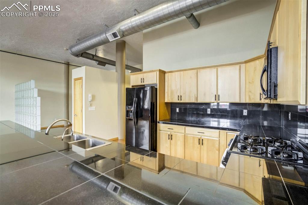 115 North Tejon Street, Unit B Colorado Springs, CO 80903 - Photo 21 of 43 a kitchen with stainless steel appliances granite countertop a sink stove and refrigerator