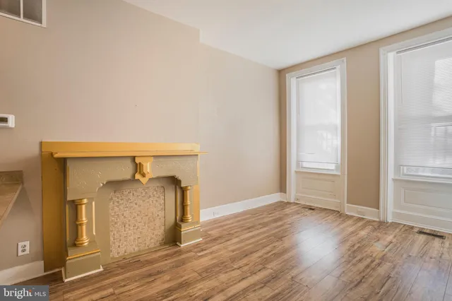 an empty room with wooden floor and a window