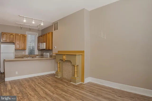 a view of a kitchen with wooden floor and a sink
