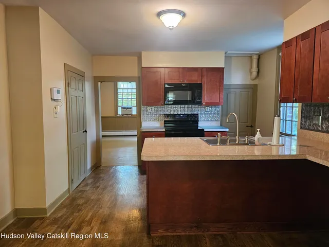 a kitchen with kitchen island granite countertop a sink stove and refrigerator