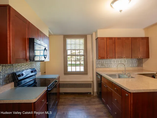 a kitchen with a sink cabinets and wooden floor