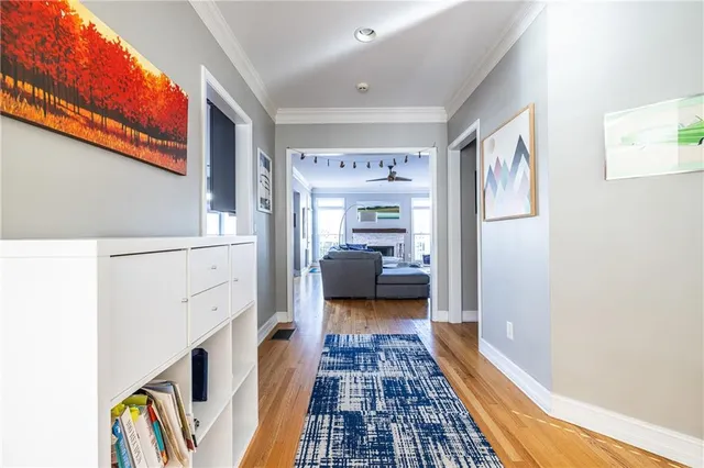 a hallway with a couch and a large window with wooden floor