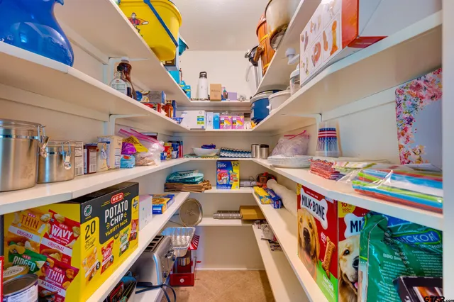 a room with stainless steel appliances kitchen island granite countertop a stove and white cabinets