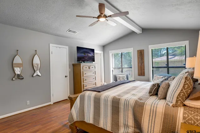 a bedroom with a bed and wooden floor